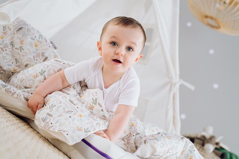 Niño en colchón con ropa de cama Niño en colchón con ropa de cama