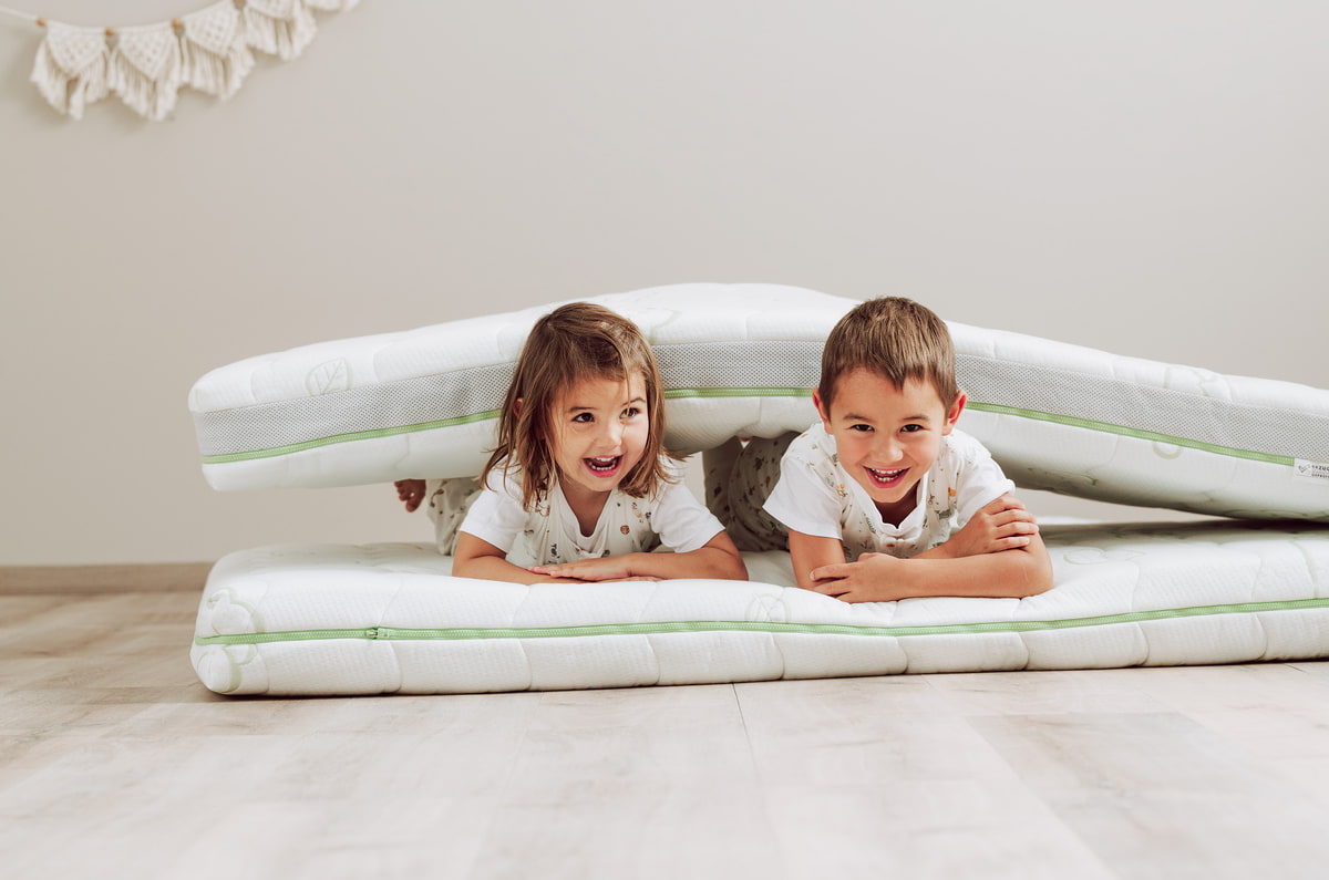 Children lying on the floor on a children's mattress Children lying on the floor on a children's mattress