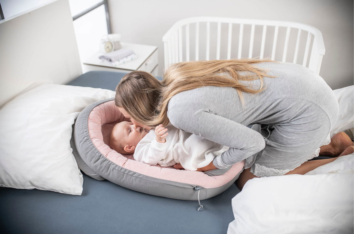 Bebé en la cama con mamá Bebé en la cama con mamá