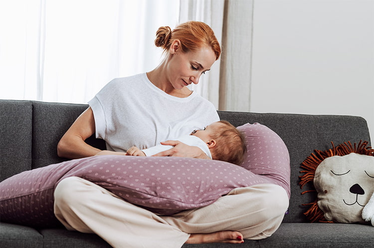 Mamá con bebé y Cojines de lactancia mientras da el pecho Cojines de lactancia