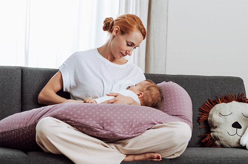mama-mit-stillkissen-beim-stillen