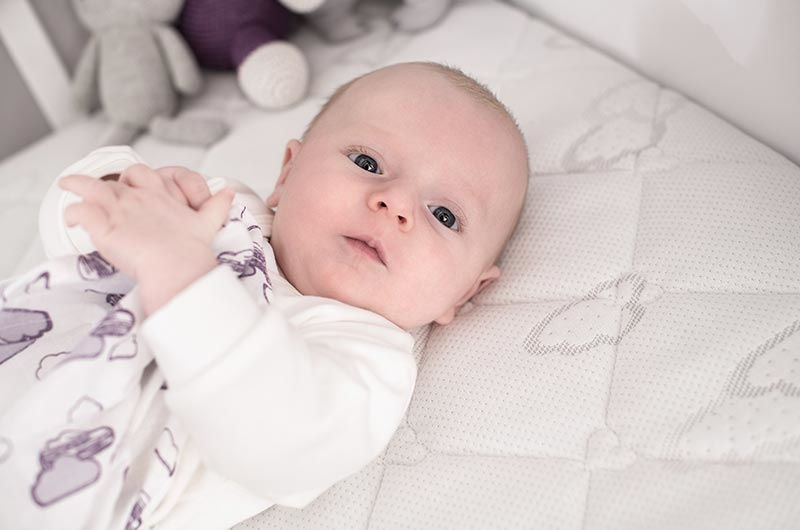 Baby im Innenschlafsack auf Matratze liegend mit Träumeland Windel Baby im Innenschlafsack auf Matratze liegend mit Träumeland Windel