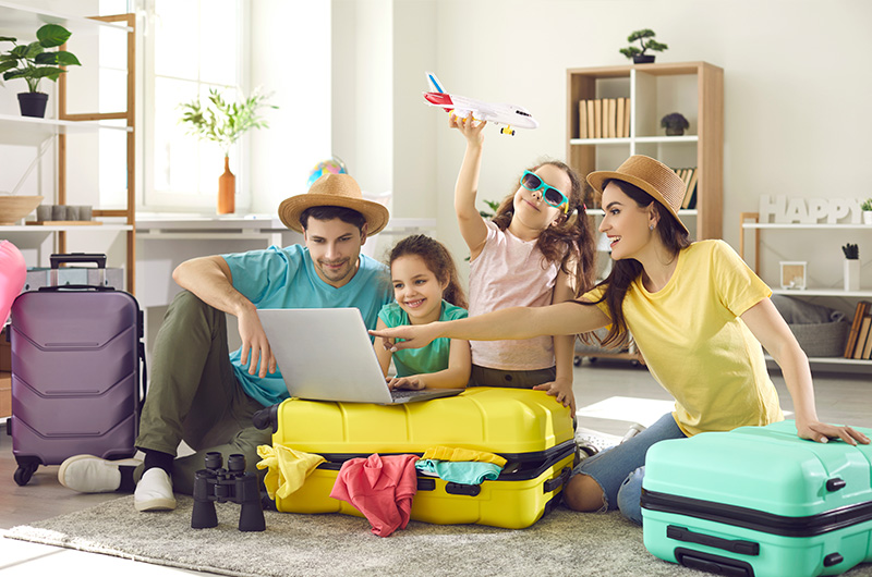 Familie mit gepackten Koffern im Wohnzimmer Familie mit gepackten Koffern im Wohnzimmer