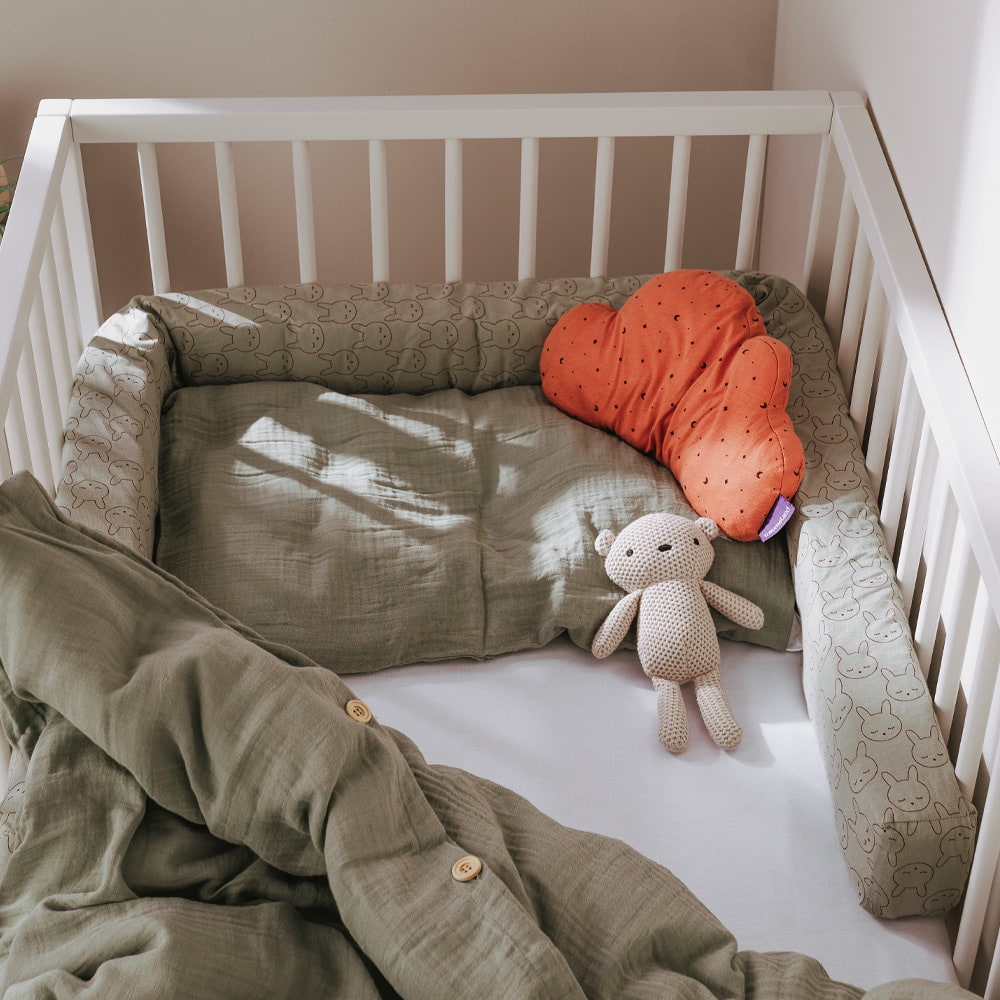 Bed with cuddly pillow, bed linen and bed snake