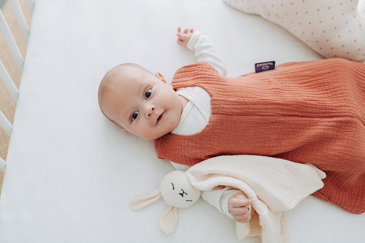 Bebé en verano con saco de dormir de verano Bebé con saco de dormir de verano en la cama