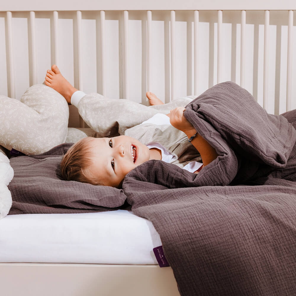 Child cuddles in bed with cozy bedding Child cuddles in bed with cozy bedding
