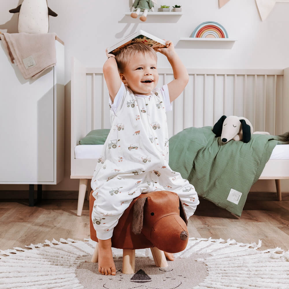 Child in pyjamas on a funny dachshund stool