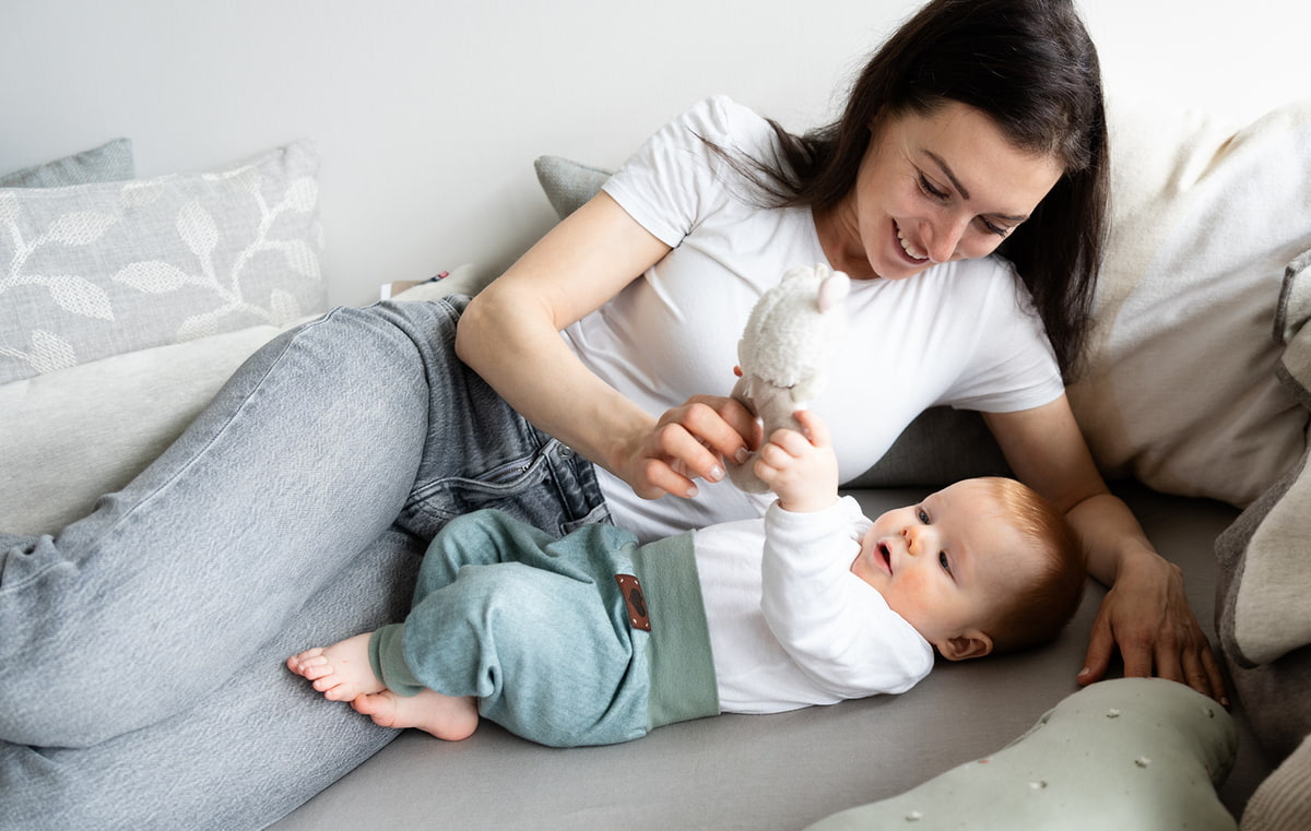 Mama spielt mit Baby auf dem Sofa Mama spielt mit Baby auf dem Sofa