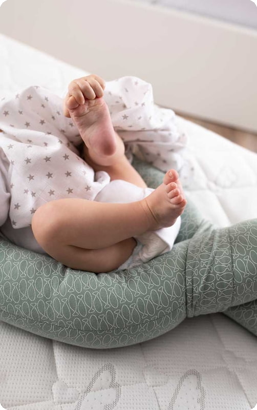 Kind hält Fuß in der Hand baby-spielt-barfuss-auge-hand-koordination-foerdern